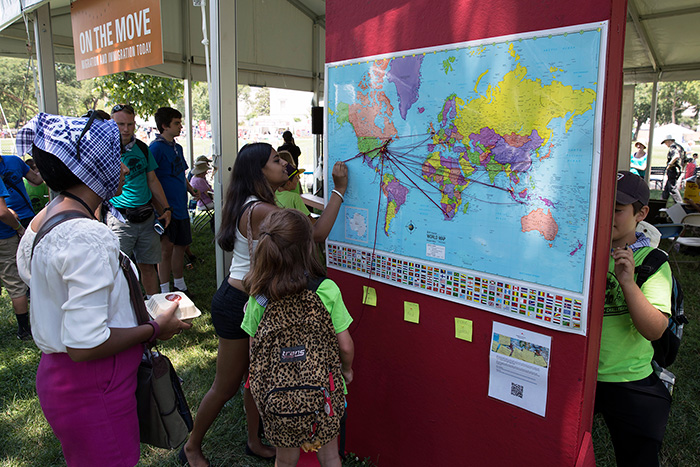 Visitors at the <em>On the Move</em> marked their birthplaces and current homes on world and U.S. maps. How long a piece of yarn is your life's journey? Photo by Francisco Guerra, Ralph Rinzler Folklife Archives