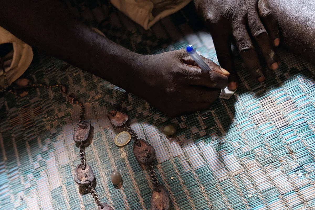 Fa diviner Koffi Akossa uses chains of kola nut pieces and other materials to gain insight into clients’ situations. Photo by Rebecca Fenton