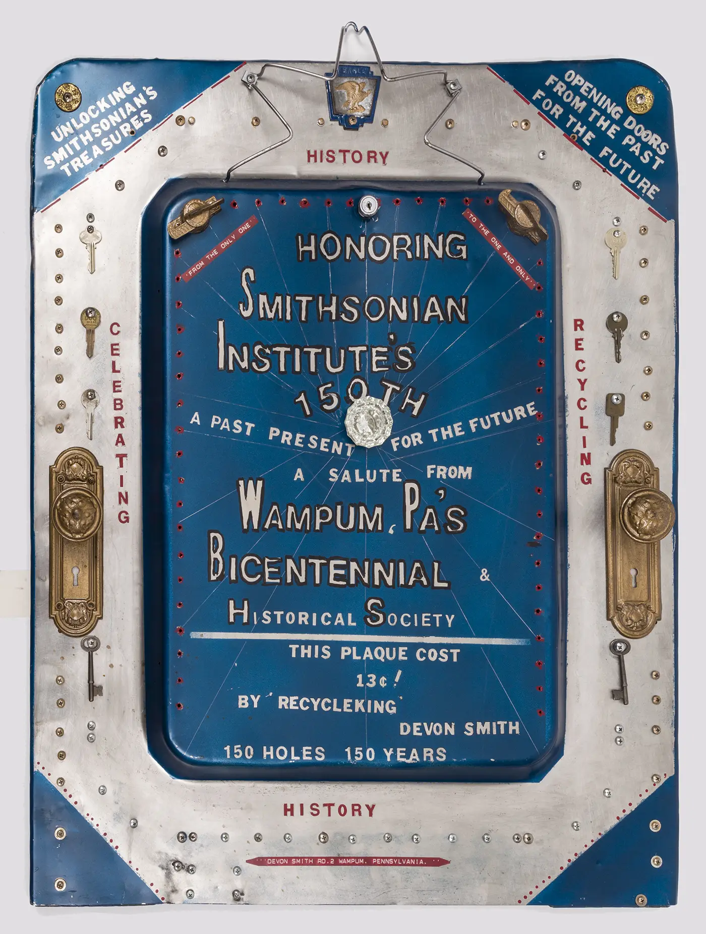 A handmade blue and silver sheet-metal plaque inscribed with words and phrases to commemorate the 150th anniversary of the Smithsonian and decorated with a variety of metal screws, keys, and two gold doorknob plates. 