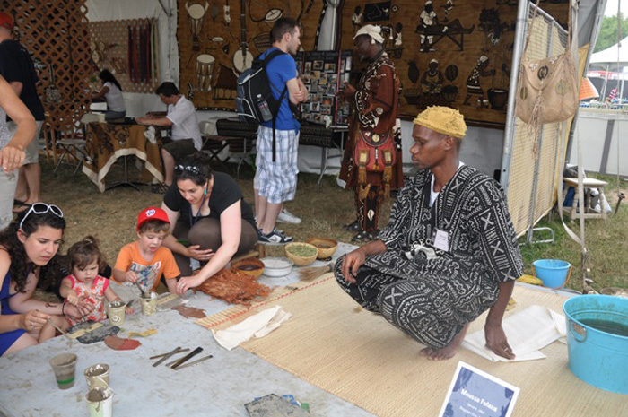 Moussa Fofana and Stephanie Beck Cohen help visitors create their own designs on cloth