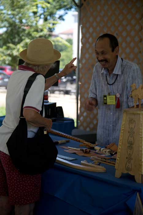 Alexander Nikolaevich Nasakaev, a Kalmyk instrument maker and woodcarver, talks with a participant in the <i>One World, Many Voices</i> program. Photo by Jennifer Graham, Ralph Rinzler Folklife Archives