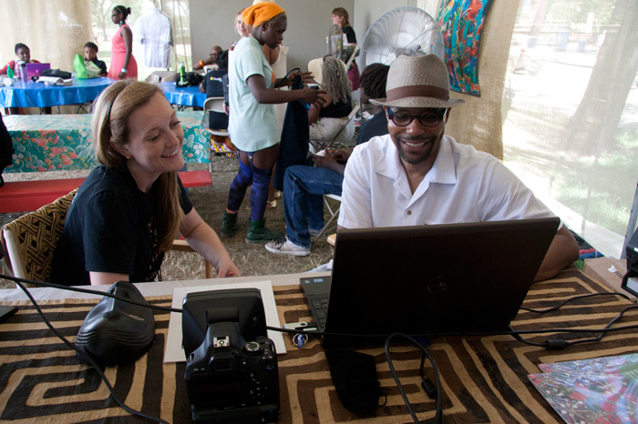 Dr. Monte O. Harris uses 3-D photography to demonstrate the diversity of beauty standards to intern Margaret Service in the Collaborative Research tent of the <i>Will to Adorn</i> program. Photo by Jennifer Graham, Ralph Rinzler Folklife Archives