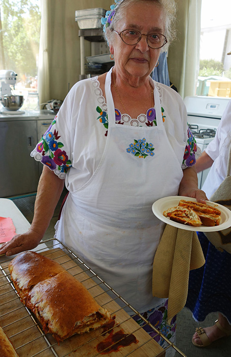 Cook Vera Szarka holds a helping of freshly made paprikás kalács.