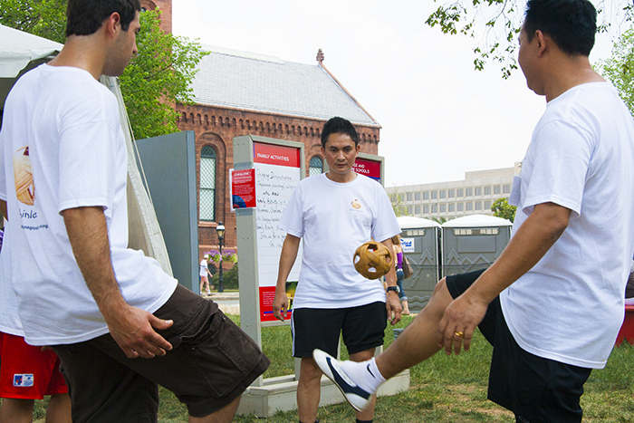 Participants and visitors play the ancient Burmese game of chinlone with a wicker ball in the Asian Pacific program at the 2010 Smithsonian Folklife Festival