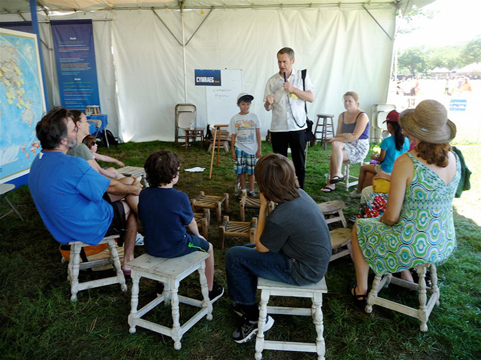 Studious visitors at the <i>One World, Many Voices</i> program’s Family Activities area spent forty-five minutes one afternoon last week composing poetry with participant Ifor ap Glyn from Caernarfon, Wales. Photo by Betty J. Belanus