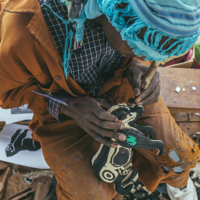 An Ocean Sole artist finishes the details of a figurine. Photo by Josh Eli Cogan, Ralph Rinzler Folklife Archives