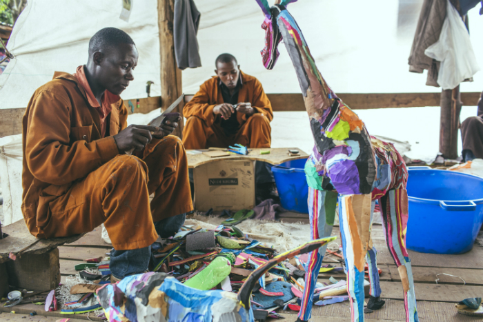 Workers at Ocean Sole finish up a giraffe in their studio. Photo by Josh Eli Cogan, Ralph Rinzler Folklife Archives