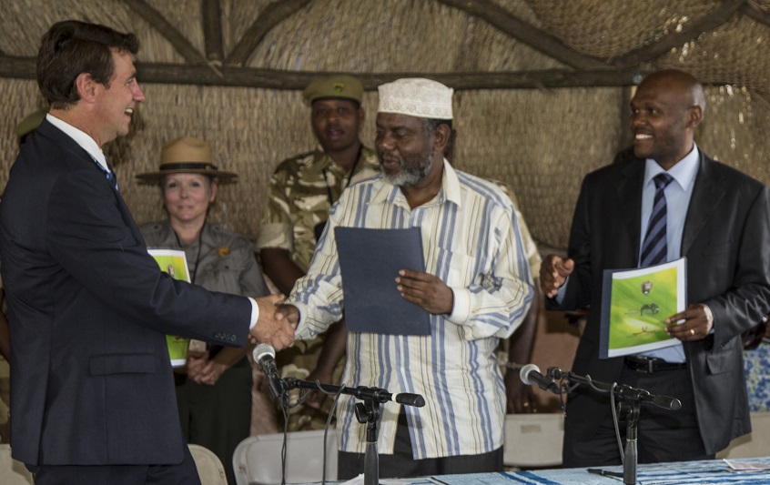 Representative for the National Park Service Chip Jenkins shakes hands with Dr. Ahmed Yassin, director of the National Museums of Kenya, with Kenya Wildlife Service deputy director Edwin Wanyoni on the right.