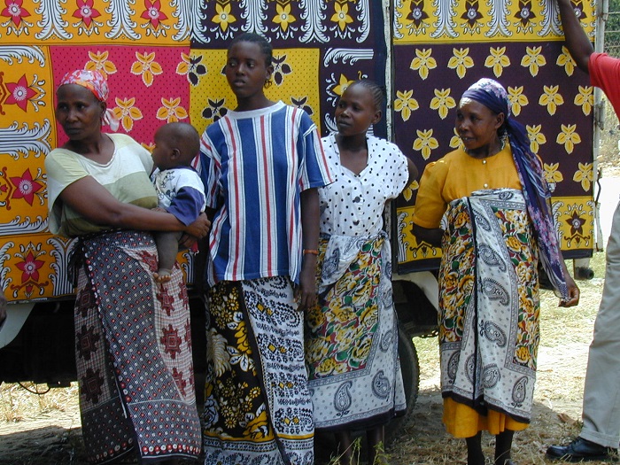 Women in front of a truck decorated with khangas.