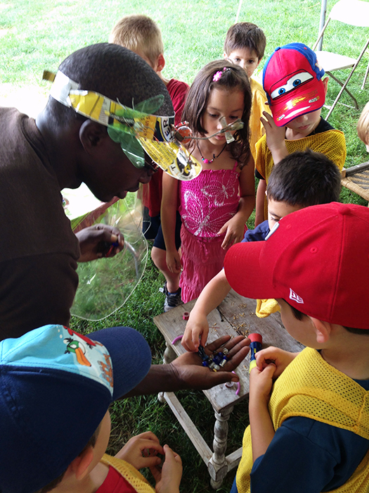 Kitengela's Patrick Kibe shares recycled beads with young visitors.