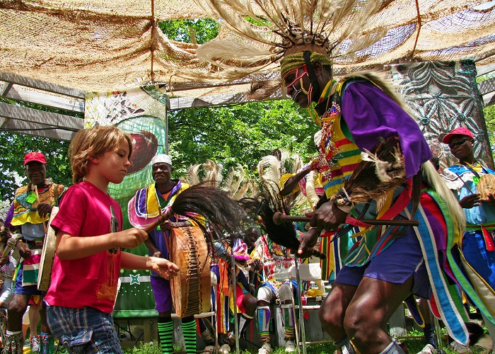 One of the Ramogi Dancers of Homa Bay County dances with a young Festival visitor.