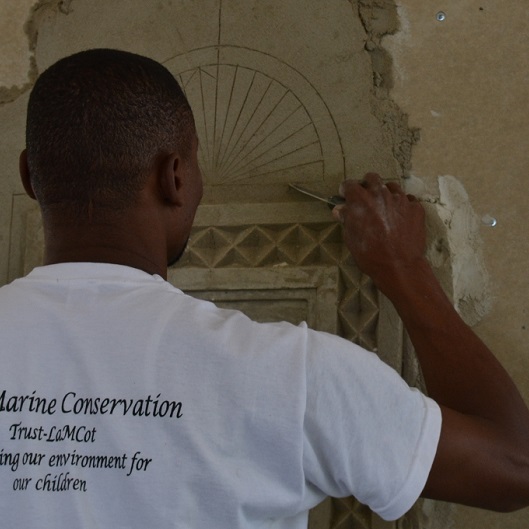 Ahmed Yusuf Suleiman carves into wet plaster.