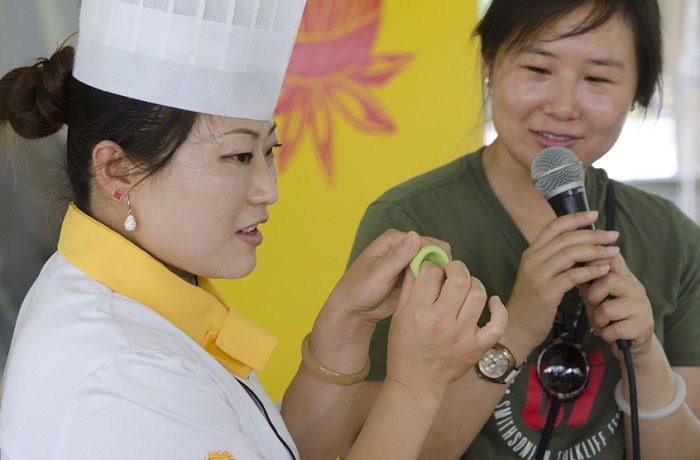 Chef Zhao Yuman molding Jade Shumai wrappers as presenter Jing Li looks on.