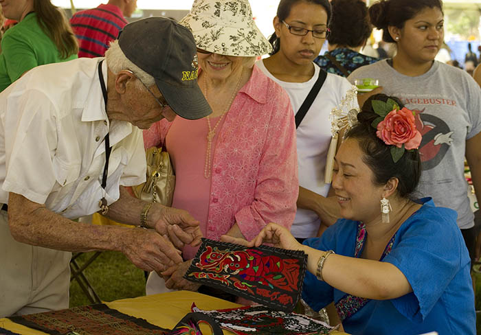 Zhang Hongying explains the embroidery process and meaning to Festival visitors. Photo by Kate Mankowski, Ralph Rinzler Folklife Archives and Collections, Smithsonian Institution