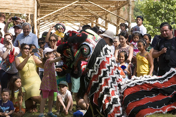 Visitors gather for an impromptu dragon dance in front of the bamboo cover walkway in the Folklife Festival's People's Parks.