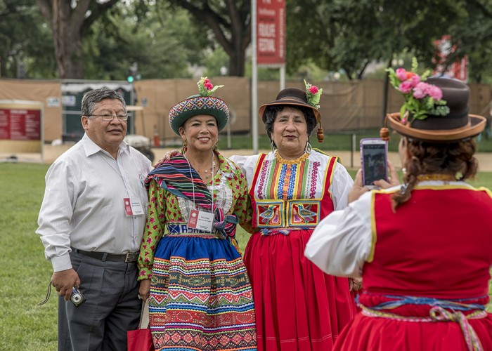 Members of the Trío de la Estudiantina Municipal de Ayacucho pose for a photo with a dancer from Tradiciones Carumeñas. Photo by Evan McGurrin, Ralph Rinzler Folklife Archives