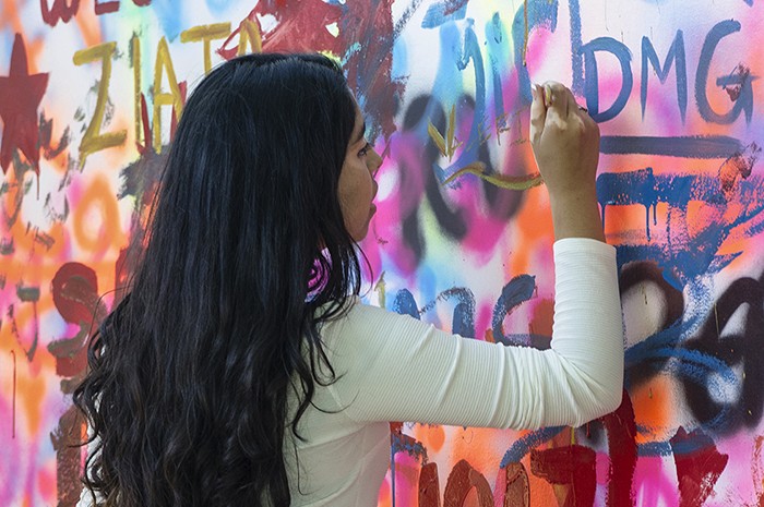 Visitors can leave their mark on the Festival near the Urban Art and Music tent, on a free-for-all mural wall. Paints are provided! Photo by Josh Weilepp, Ralph Rinzler Folklife Archives