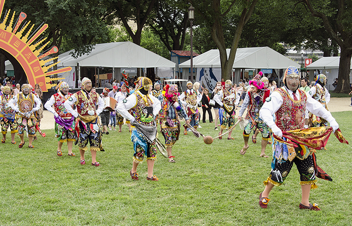 Our largest group, representing the masked dance of La Fiesta de la Virgen del Carmen, marched from their tent to La Juerga. Photo by Josh Weilepp, Ralph Rinzler Folklife Archives