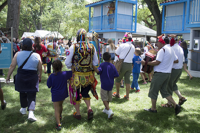 La Fiesta de la Virgen del Carmen from Paucartambo comes to life on the National Mall, as the Contradanza troupe invites visitors to join their parade through the trees. Photo by Sarah Bluestein, Ralph Rinzler Folklife Archives