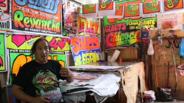 Chicha artist MONKY describes his silkscreen process in his workshop in Peru. Photo by Joshua Eli Cogan, Ralph Rinzler Folklife Archives