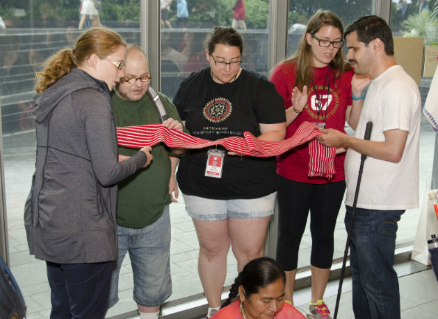 Accessibility Coordinator Lilli Tichinin, with interns Cyle Cucinotta and Sarah Blakeney, leads visitors on a tactile and verbal description tour. Photo by Josh Weilepp, Ralph Rinzler Folklife Archives