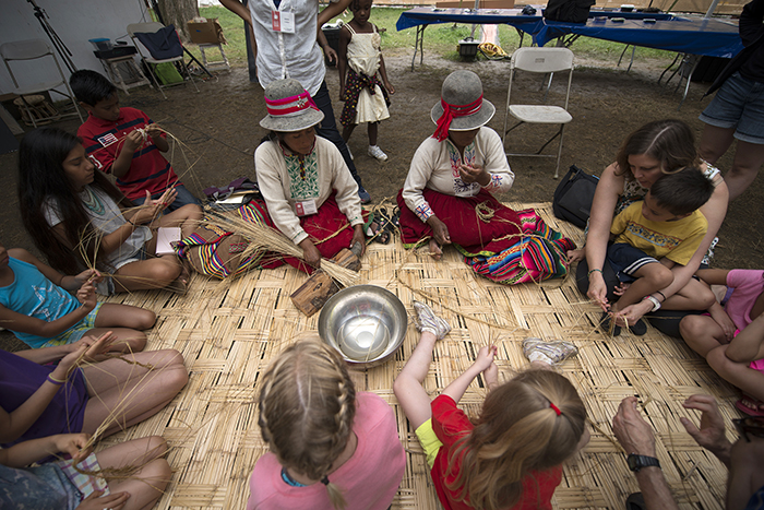 Visitors helped Alejandrina Huillca Puma and Alejandrina Ayma de Mamani prepare <em>ichu</em> grass. Once softened, the grass will be braided into rope for the Q'eswachaka bridge. Photo by Walter Larrimore, Ralph Rinzler Folklife Archives