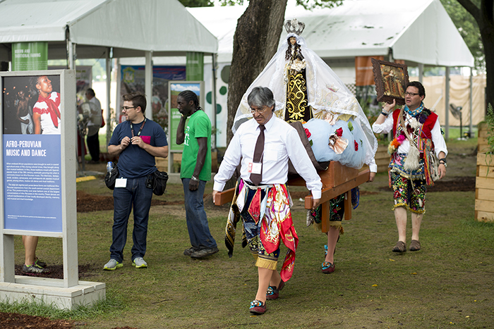 As the National Park Service asked for the Mall to be evacuated, the dancers from Paucartambo brought the Virgen del Carmen to her storage container to stay safe and dry. Photo by Pruitt Allen, Ralph Rinzler Folklife Archives