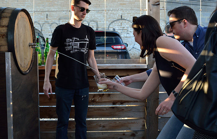 Tim Prendergast (left) directs guests as they fill their cups with cider at the Txotx! on April 17. Photo by Greyson Harris