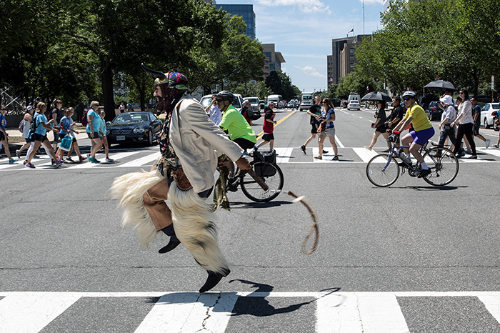 Grupo Nuu Yuku and Banda Brillo capped off the opening ceremony by leading a procession east on Jefferson Avenue to the Festival grounds, blowing horns and cracking whips all the way. Photo by Francisco Guerra, Ralph Rinzler Folklife Archives