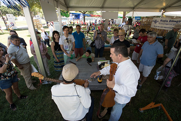 Instrument maker Ramón Gutiérrez (in white, left) had been working on building a requinto jarocho since the Festival began on Wednesday. Today he completed it, and instantly started a jam with Sounds of California presenter Russell Rodriguez (right). Photo by Francisco Guerra, Ralph Rinzler Folklife Archives