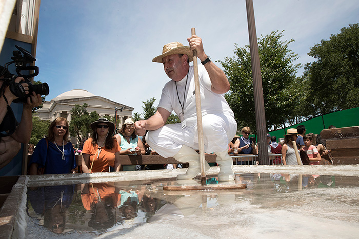 Edorta Loma shows off the natural salt crystals that have grown in the Folklife Festival salt flats. Photo by Francisco Guerra, Ralph Rinzler Folklife Archives