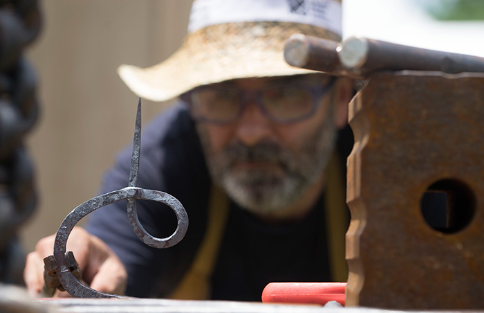 César Alcoz puts the finishing touches on a candlestick. Photo by Caroline Angelo, Ralph Rinzler Folklife Archives