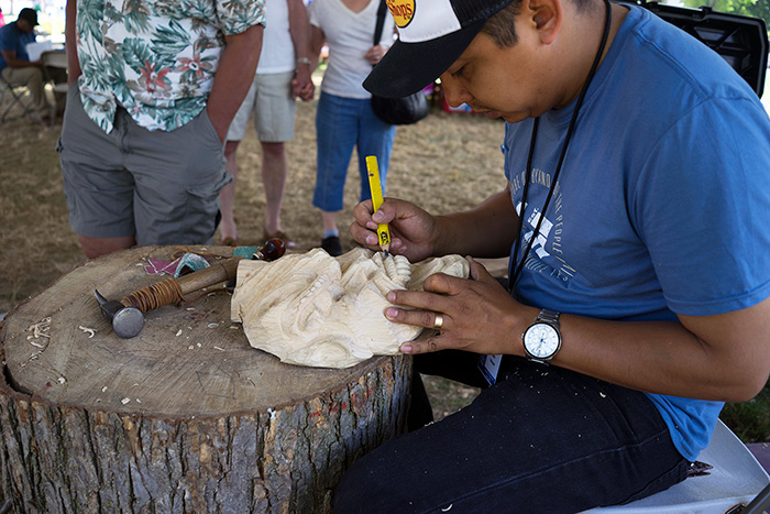 Alex Vásquez worked one last day on this <em>diablo</em> mask, which started as a solid cube of wood at the beginning of the Festival. The mask will be donated to the Smithsonian. Photo by Caroline Angelo, Ralph Rinzler Folklife Archives