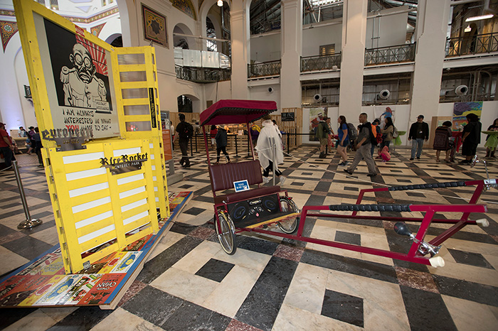 After the rain drove us out of the tents, we moved our events inside the Arts and Industries Building. Throughout the Festival, visitors can see this artwork on display: <em>Goon Garage featuring The Rice Rocket</em> by Clement Hanami, part of the <em>On the Move</em> program. Photo by Francisco Guerra, Ralph Rinzler Folklife Archives