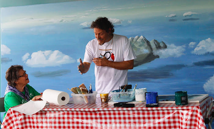 Jesus Maria Lazkano explaining his painting style to a Folklife Festival volunteer. Photo by SarahVictoria Rosemann