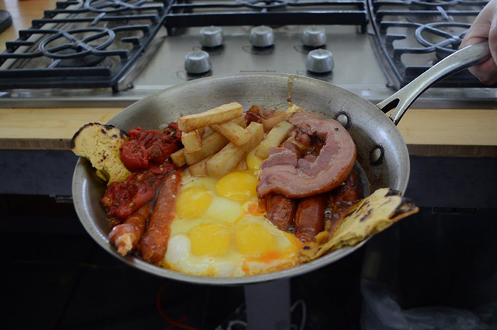 <em>Sarteneko</em> (Basque skillet) flanked by two pieces of <em>talo</em> bread, prepared by chefs Igor Ozamiz Goiriena and Igor Cantabrana. Photo by Ravon Ruffin, Ralph Rinzler Folklife Archives