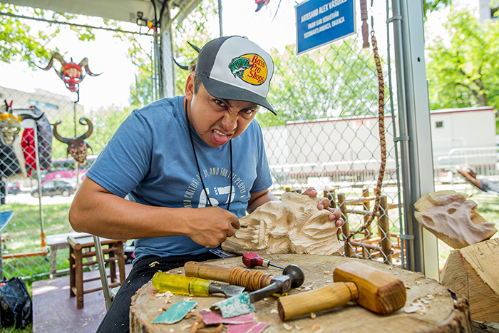 Mask maker Alex Vásquez mimcs the face of his latest work. Photo by Prayoon Charoennun