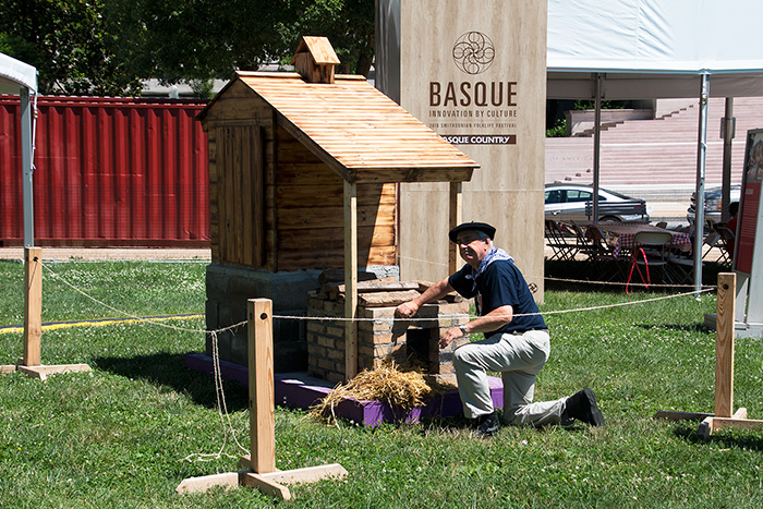 Felix Goiburu Errazquin tends to the Idiazabal cheese in the custom smoker built for the Folklife Festival. Photo by Hank Douglas, Ralph Rinzler Folklife Archives