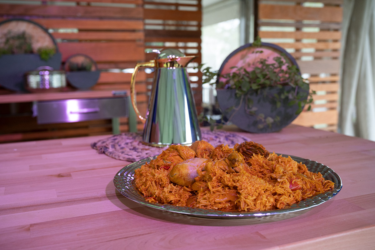 A silver platter of yellow rice and chicken.