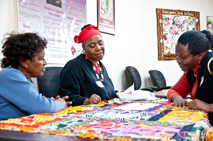 Workshop participants admire a quilt-in-process made of fabric from Nigeria.