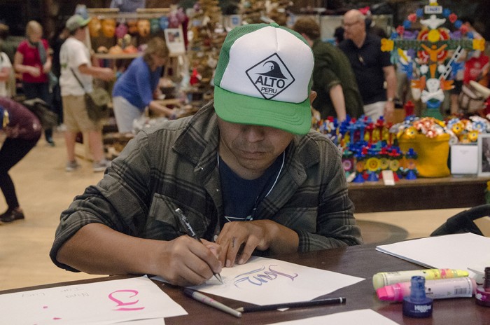 In the Marketplace, Elliot Túpac delighted visitors by writing out their names in beautiful calligraphy. Photo by Josh Weilepp, Ralph Rinzler Folklife Archives