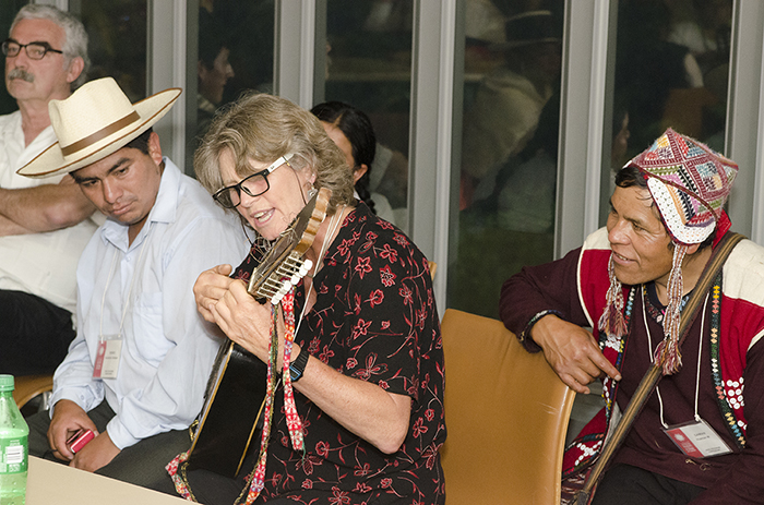 As participants, presenters, and staff took shelter inside the museum, the festivities continued in the green room. Wachiperi presenter Holly Wissler took a turn on the Cusco weavers' sixteen-string guitar. Photo by Josh Weilepp, Ralph Rinzler Folklife Archives